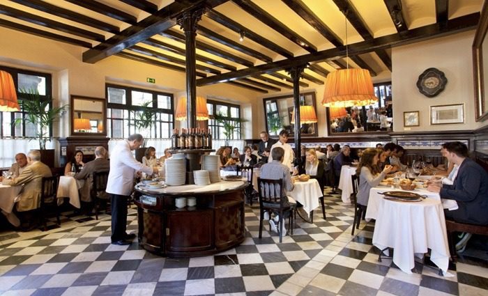 interior of restaurante 7 portes in barcelona with waiter serving diners