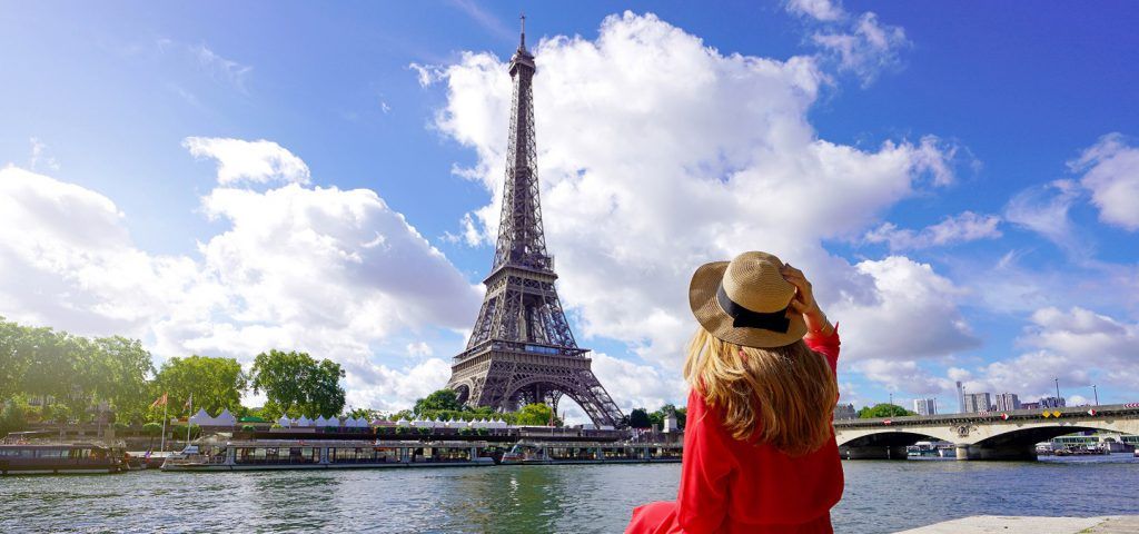 Women standing in front of the Eiffel Tower during the day.