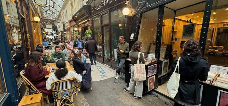 Sean P Finelli taking notes on his phone while doing research in Paris in Passages de Panorama