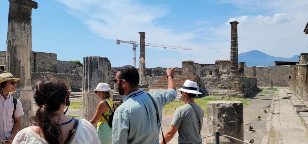 Group of people taking a tour of the ruins of Pompeii.