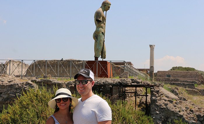 couple in front of pompeii statue