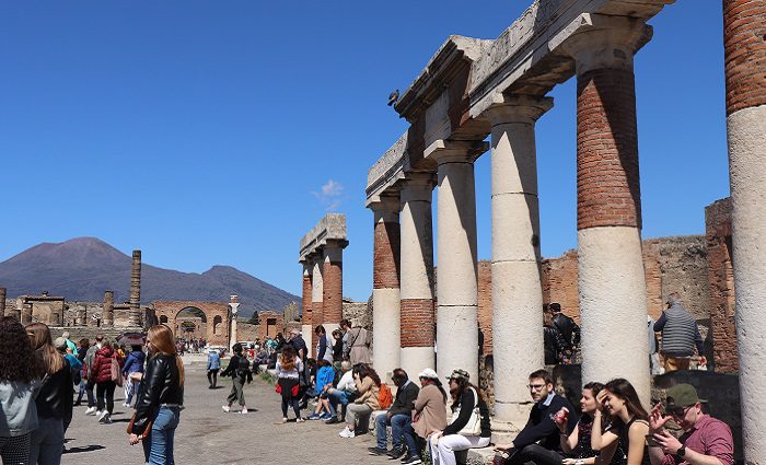 people sitting near pillars in pompeii