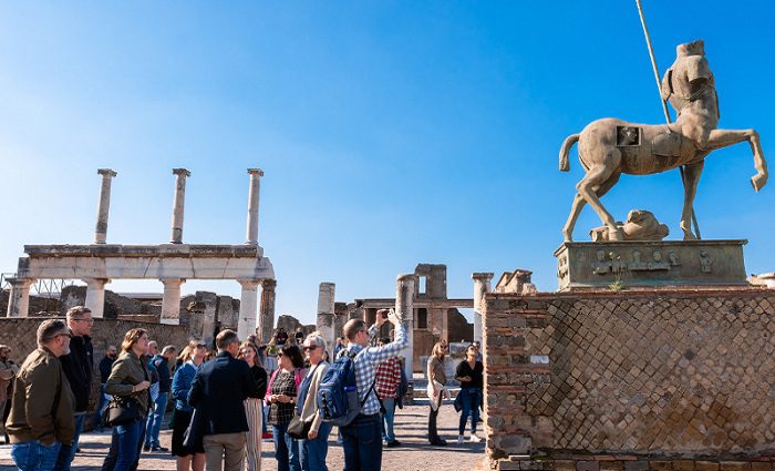 people standing at statue in pompeii