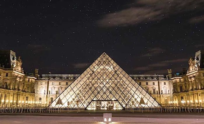 the exterior of the Louvre and the glass pyramid at night