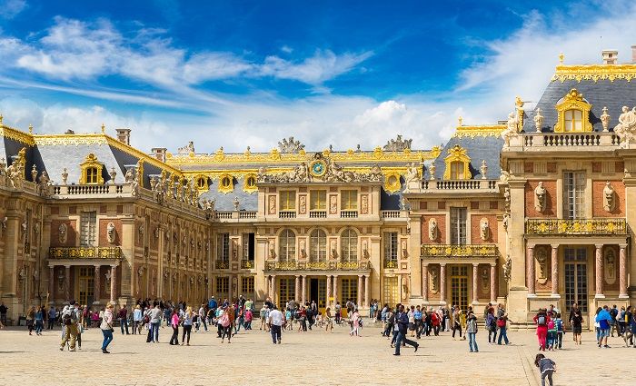 The exterior of the Grand Trianon Versailles, France, with visitors in the foreground.