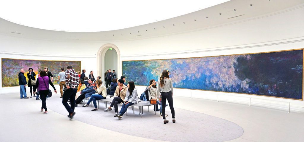Visitors admire the giant waterlily Nympheas paintings by impressionist painter Claude Monet at the Musee de l Orangerie museum in Paris.