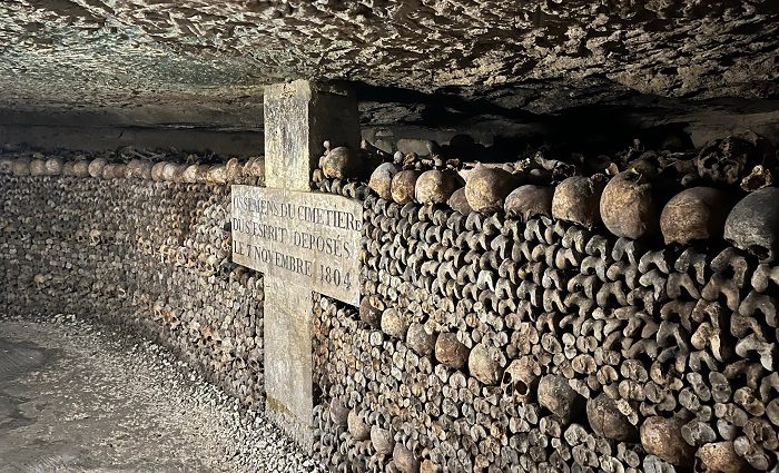 wall of human bones stacked in the Paris Catacombs
