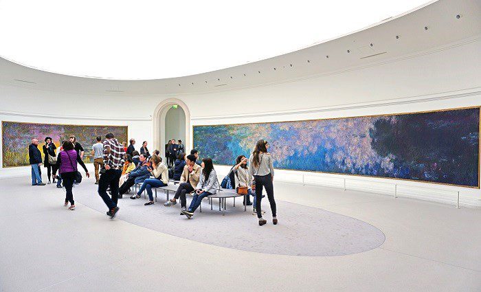 Visitors admire the giant waterlily Nympheas paintings by impressionist painter Claude Monet at the Musee de l Orangerie museum in Paris.