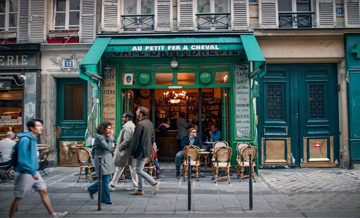 Man sitting at an outdoor table of a Parisian restaurant