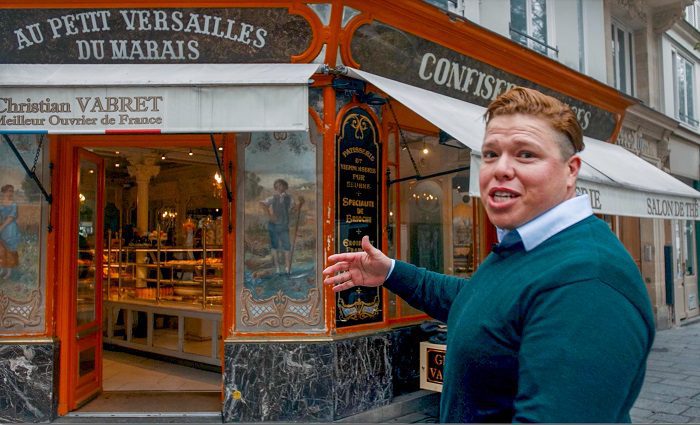 Man in front of a restaurant, Au Petite Versailles, in Paris 