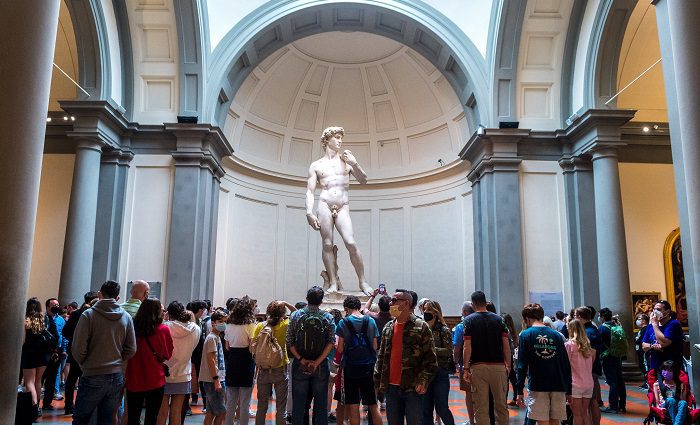 Group of visitors standing in fron of the David in the Accademia Gallery Florence