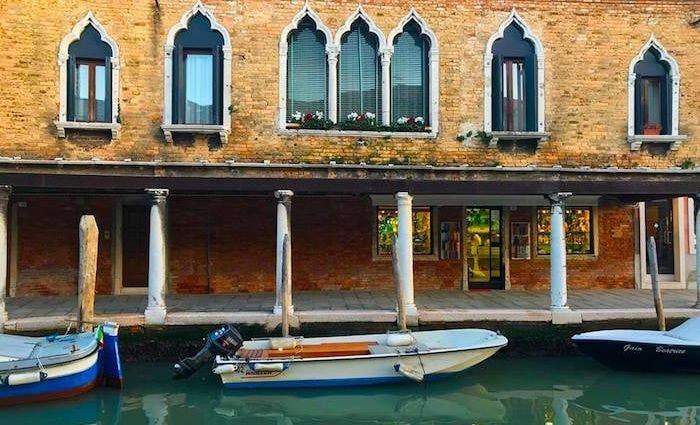 a boat sits in front of one of the best hotels in Venice.