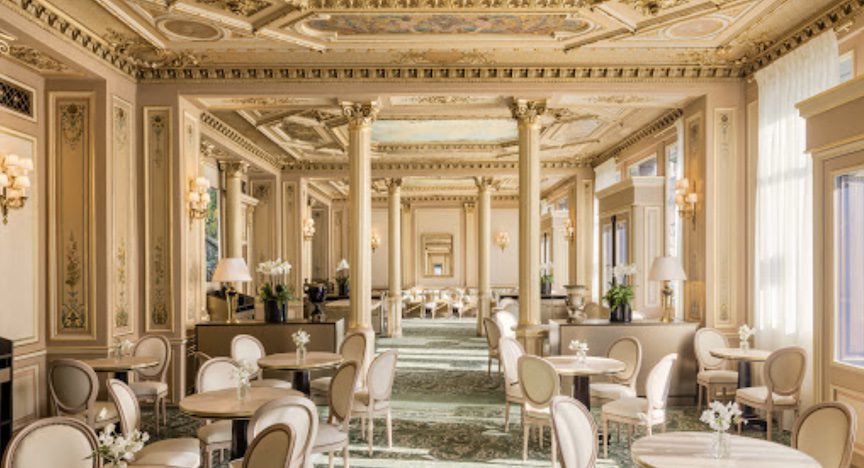 Ornate columns with sage green velvet chairs.