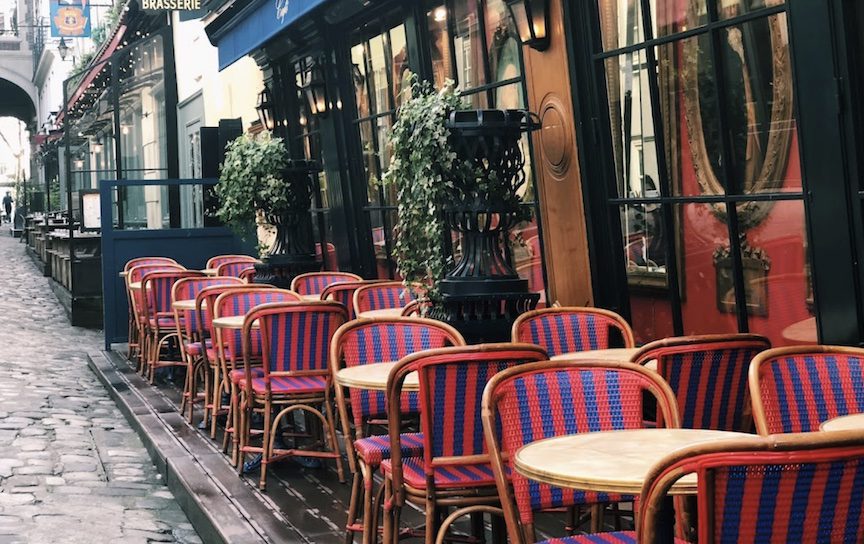 Blue and red woven chairs next to wooden tables.