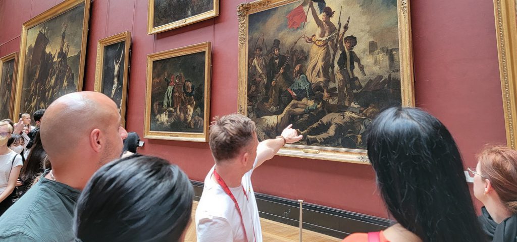 guide pointing at lady leading liberty