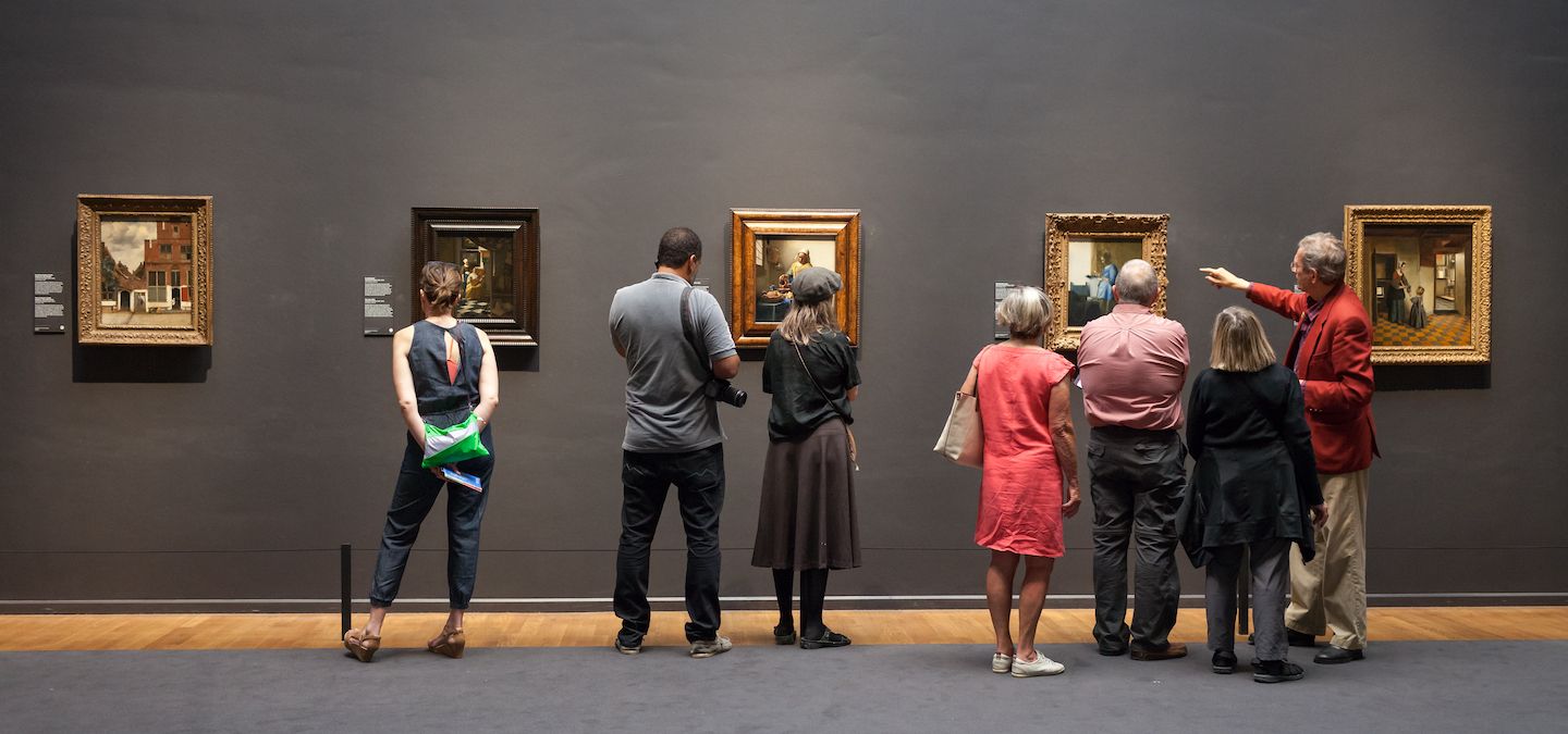 Group of people looking at paintings at the Rijksmuseum.