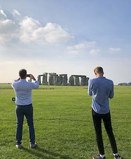 two guys taking pictures of Stonehenge