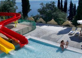 Adults and kids playing in a pool with slides.
