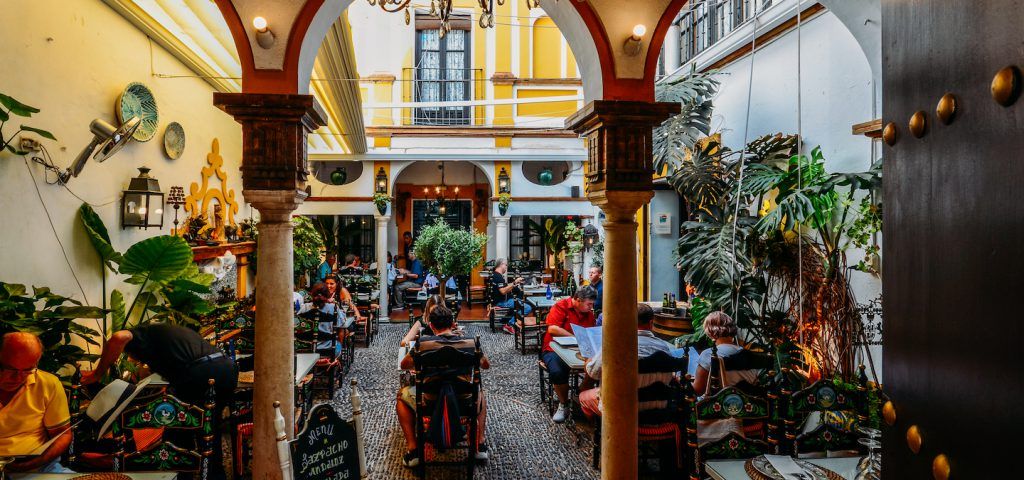 Indoor courtyard with people eating dinner.