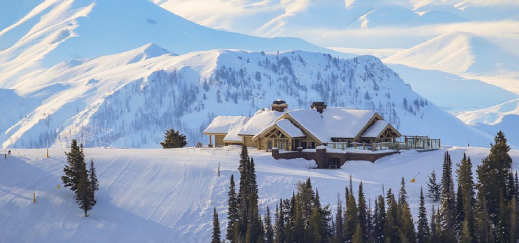Exterior of cabin at the top of a snow covered mountain.
