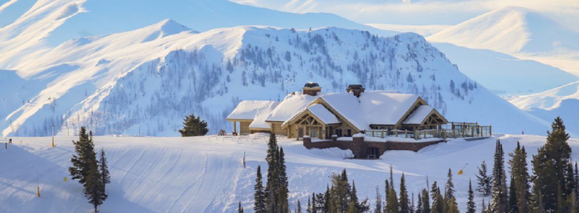 Exterior of cabin at the top of a snow covered mountain.