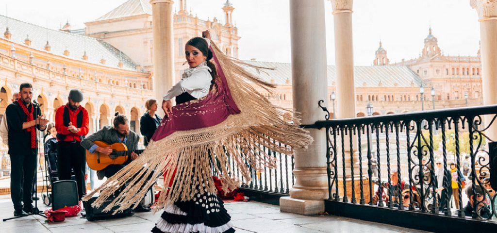 Women dancing with people playing instruments in the background.