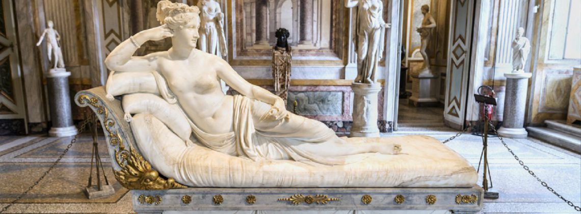 Marble statue of woman resting on a bed.