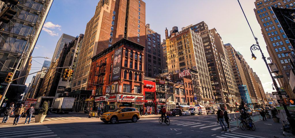 People walking the streets of NYC with cars.