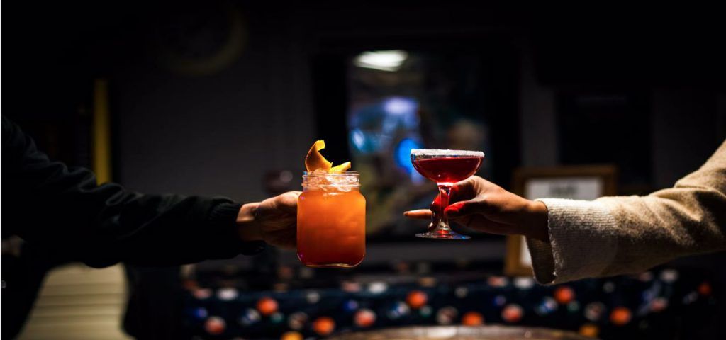 Two people holding up drinks.