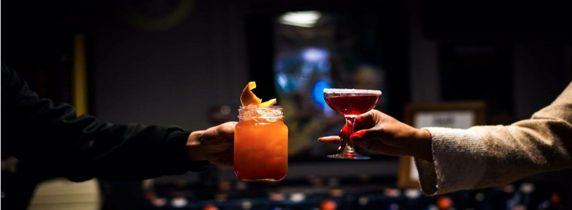 Two people holding up drinks.