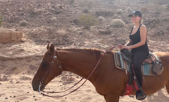 Woman riding a house through the deserts of Vegas.