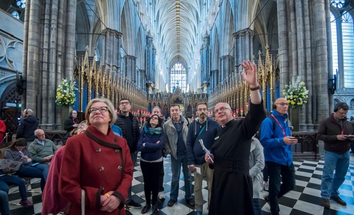 people and guide standing in Westminster abbey