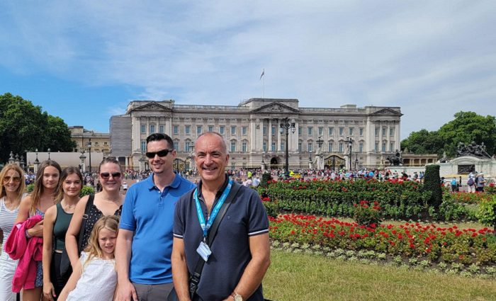 people posing in front of buckingham palace