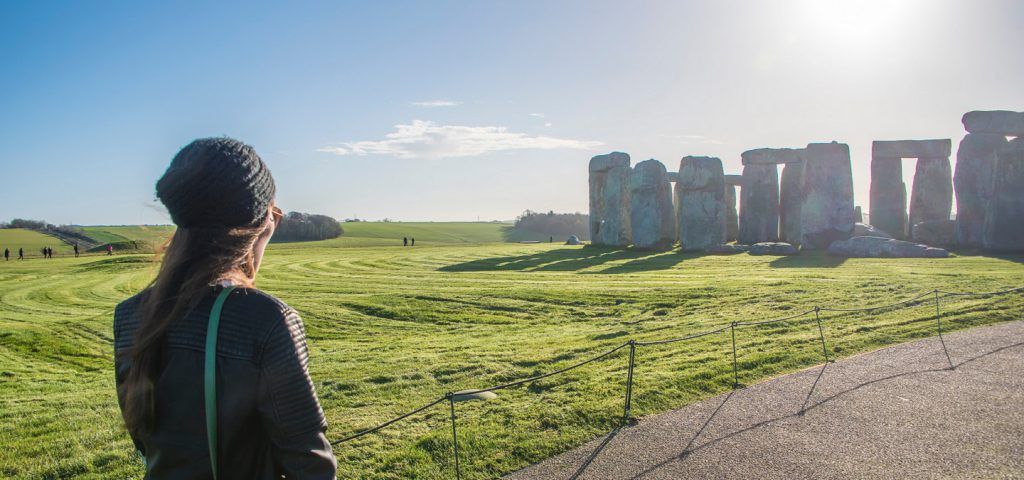 Girl looking at Stonehenge in the daytime.
