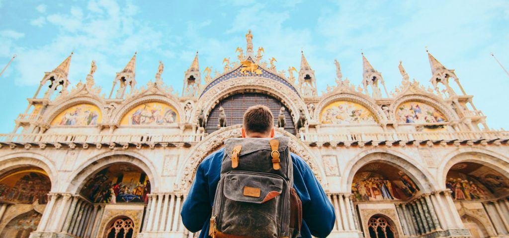 Man standing in front of St Marks Basilica.