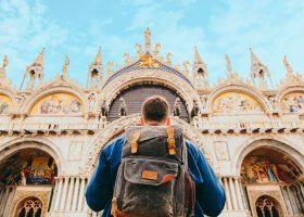 Man standing in front of St Marks Basilica.