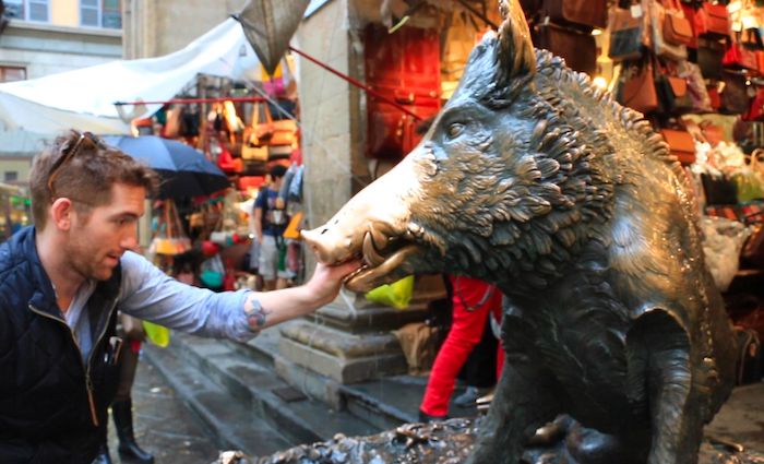 feeding Il Porcellino a quarter in Florence