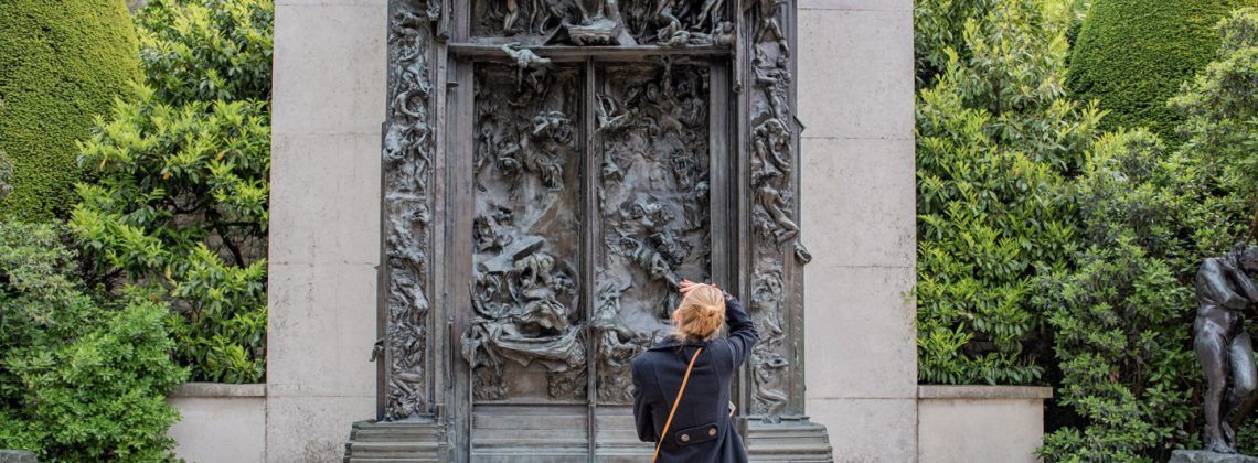 Woman looking at the gates of Musee Rodin.