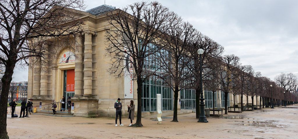 Exterior of Musee l'orangerie with people and a row of trees
