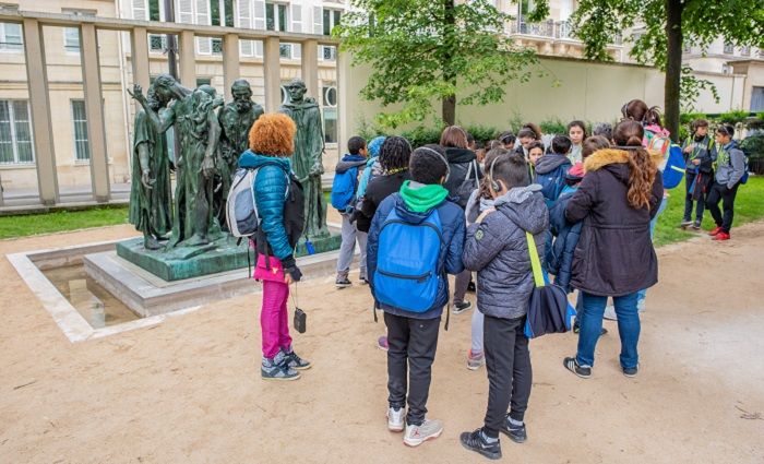 A tour guide showing a group of visitors a statue in the gardens of the Musée Rodin in Paris