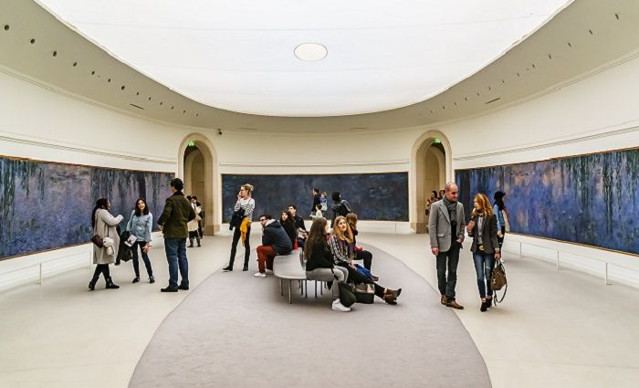 Visitors of the Musée de l'Orangerie admiring Monet's water lilies.