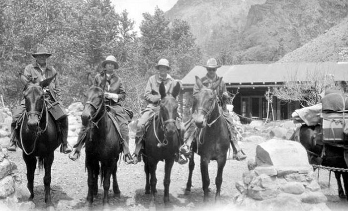 black and white photo of people on mules at phantom ranch