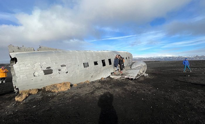 people taking picture at plane wreck