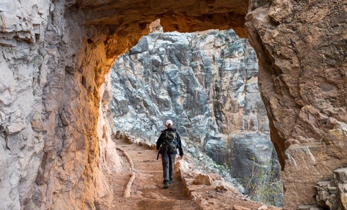 woman walking through arch on bright angel trail