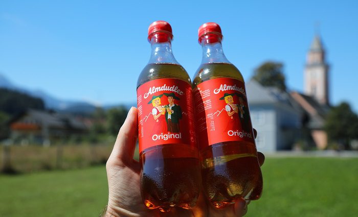 person holding two bottles of Almdudler a popular local soft drink in vienna