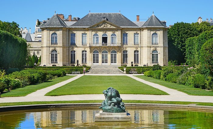 Facade of Hotel Biron and Rodin Museum in Paris with pond in foreground and Rodin scuplture as a centrepiece