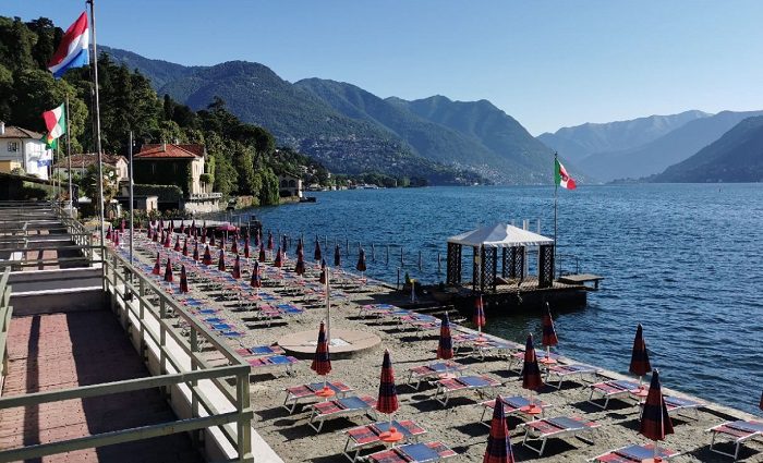 chairs and umbrellas on lake como beach