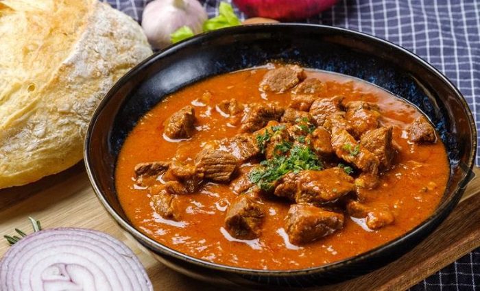 Rindsgulasch, a popular local food to try in Vienna, in a bowl with chunks of meat and rich gravy