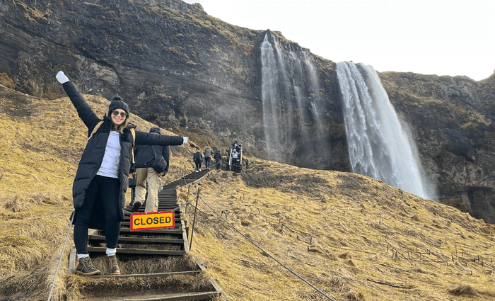 woman on stairs of Seljalandsfoss waterfall 