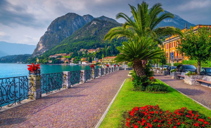 landscaped walking path near a lake and mountains